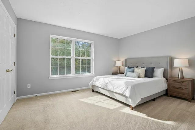 a spacious bedroom with a bed and a window