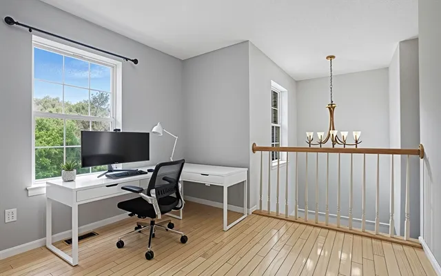 a view of a workspace with furniture and a window