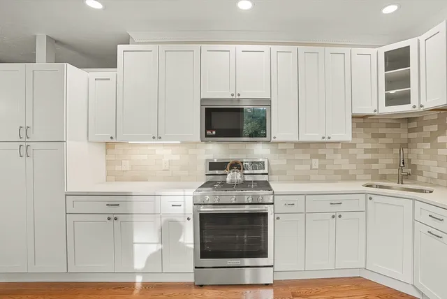 a kitchen with white cabinets and white appliances