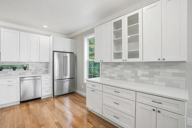 a kitchen with stainless steel appliances granite countertop a refrigerator sink and white cabinets