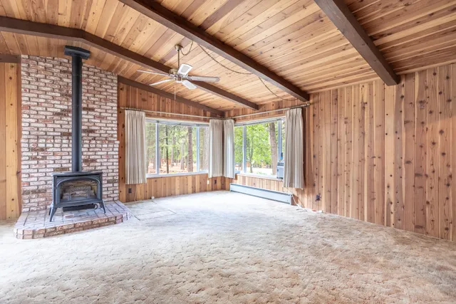 a view of an empty room with a fireplace and a large window