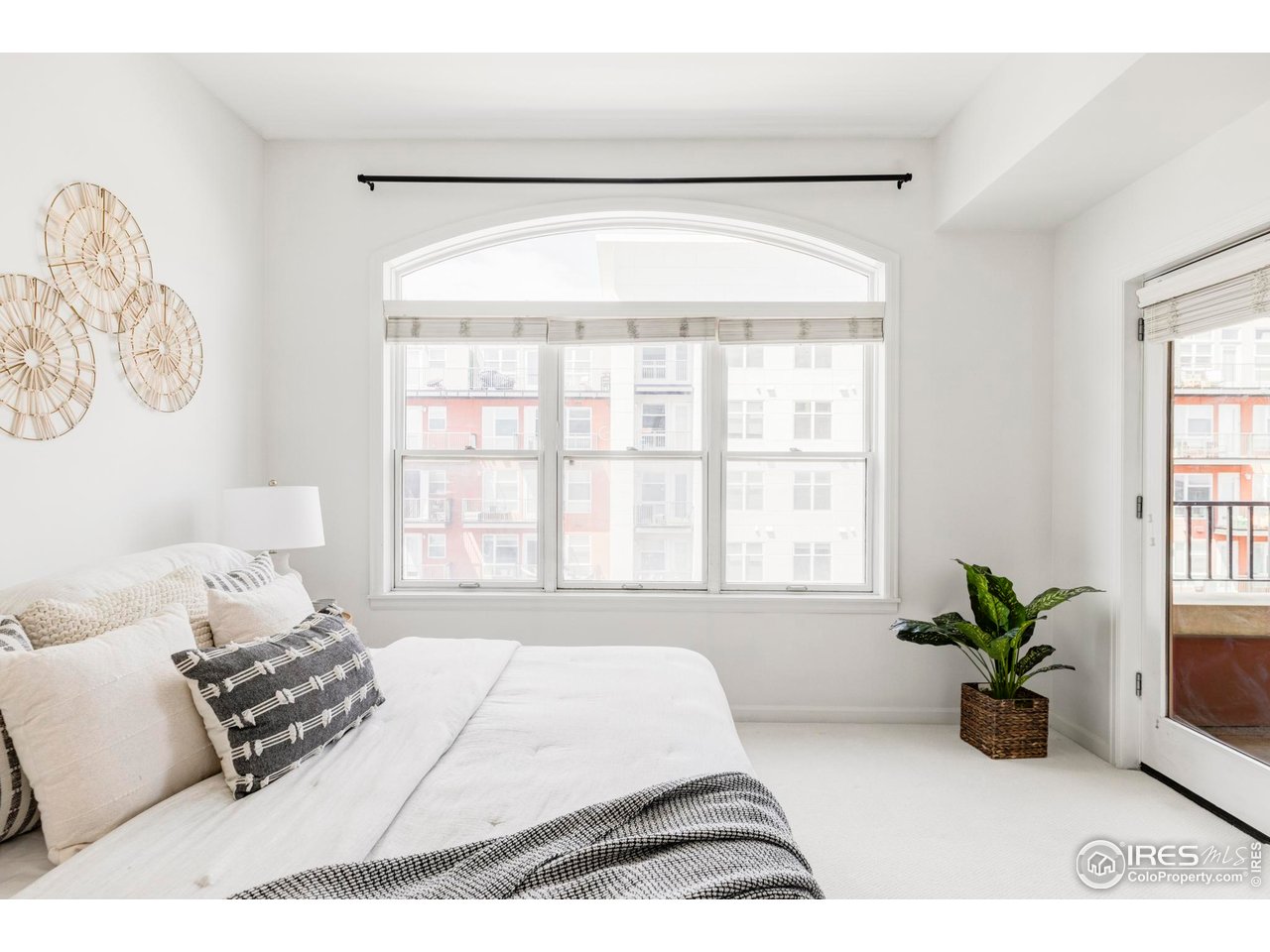 1950 Logan Street, Unit 1013 Denver, CO 80203 - Photo 13 of 23 a bed sitting in a bedroom next to a window with potted plant