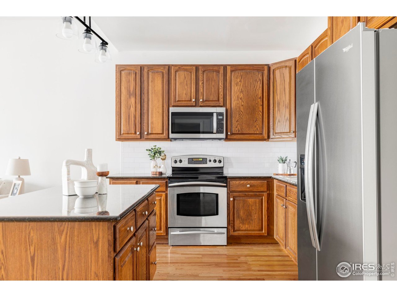 1950 Logan Street, Unit 1013 Denver, CO 80203 - Photo 5 of 23 a kitchen with stainless steel appliances a stove a sink a microwave and refrigerator