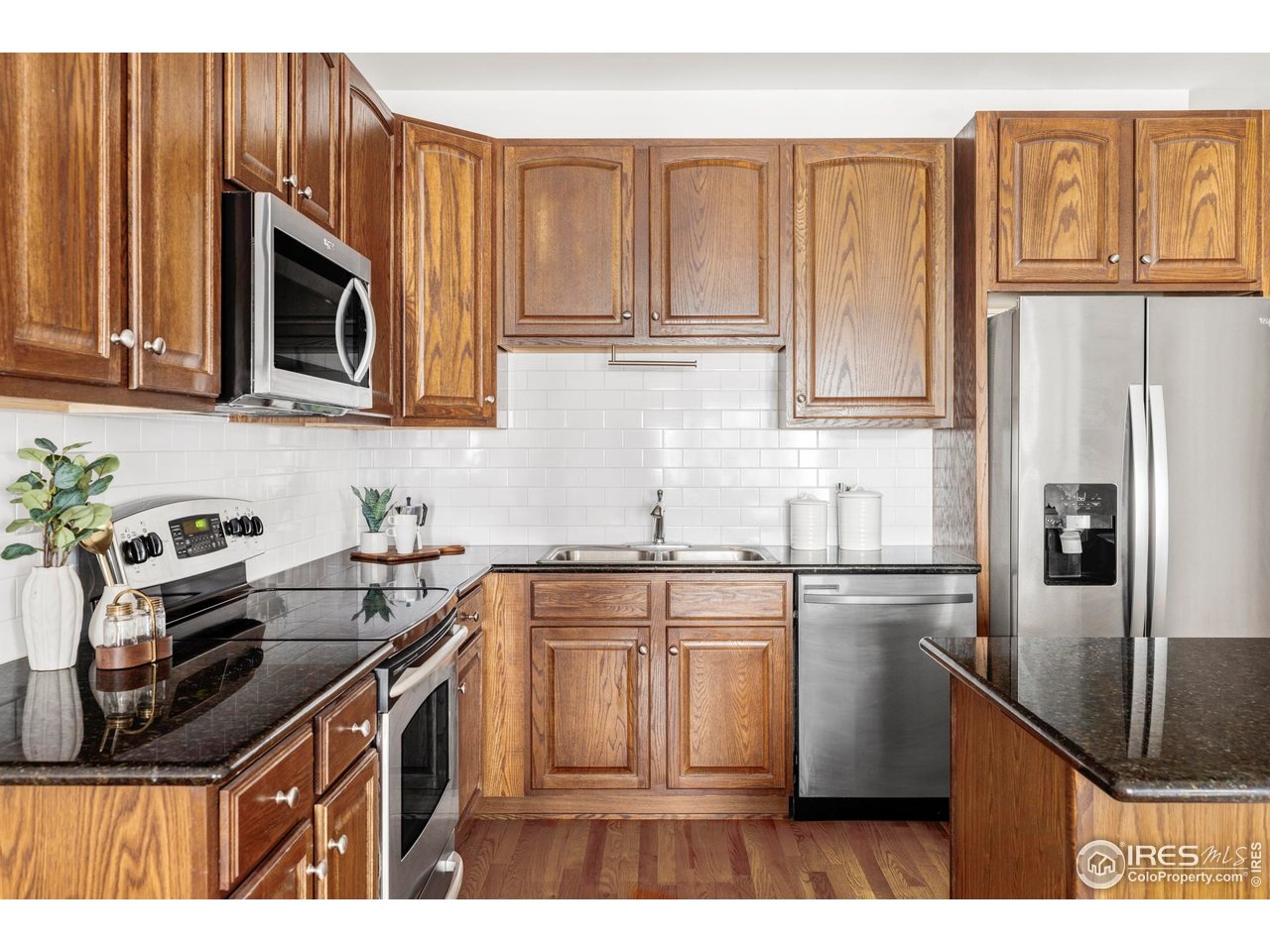 1950 Logan Street, Unit 1013 Denver, CO 80203 - Photo 6 of 23 a kitchen with kitchen island granite countertop a sink stove and refrigerator