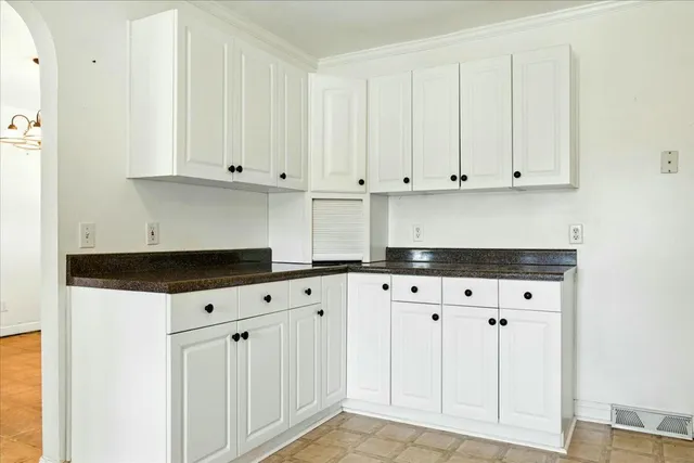 a kitchen with granite countertop white cabinets and a white stove