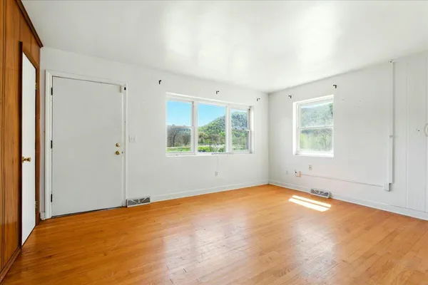 a view of empty room with wooden floor