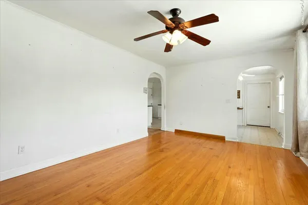 a view of a big room with wooden floor and a ceiling fan