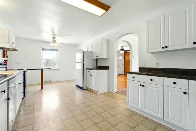 a kitchen with granite countertop a sink cabinets and stainless steel appliances