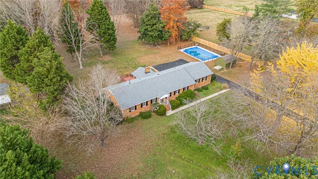 an aerial view of a house with a yard and lake view
