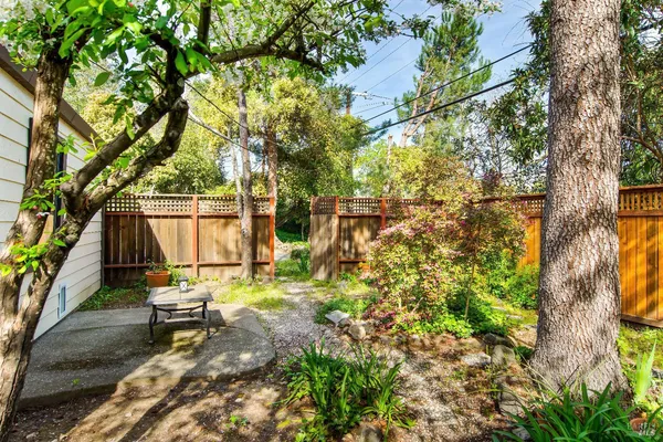 a backyard of a house with table and chairs under an umbrella