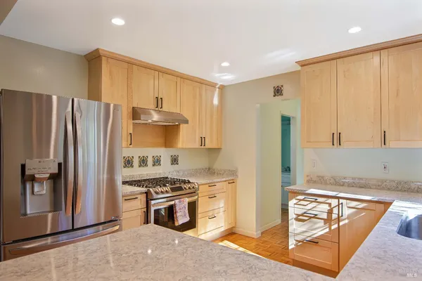 a kitchen with stainless steel appliances granite countertop a refrigerator stove and sink