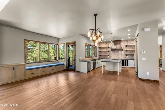 a kitchen with stainless steel appliances granite countertop wooden floor window and cabinets
