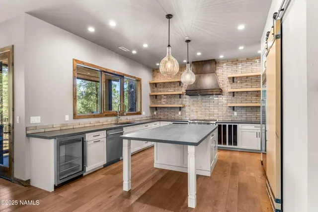 a kitchen with stainless steel appliances granite countertop a sink a stove and a refrigerator