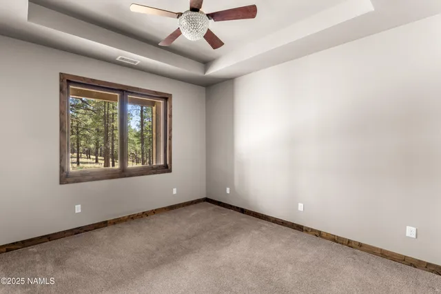 an empty room with windows and ceiling fan
