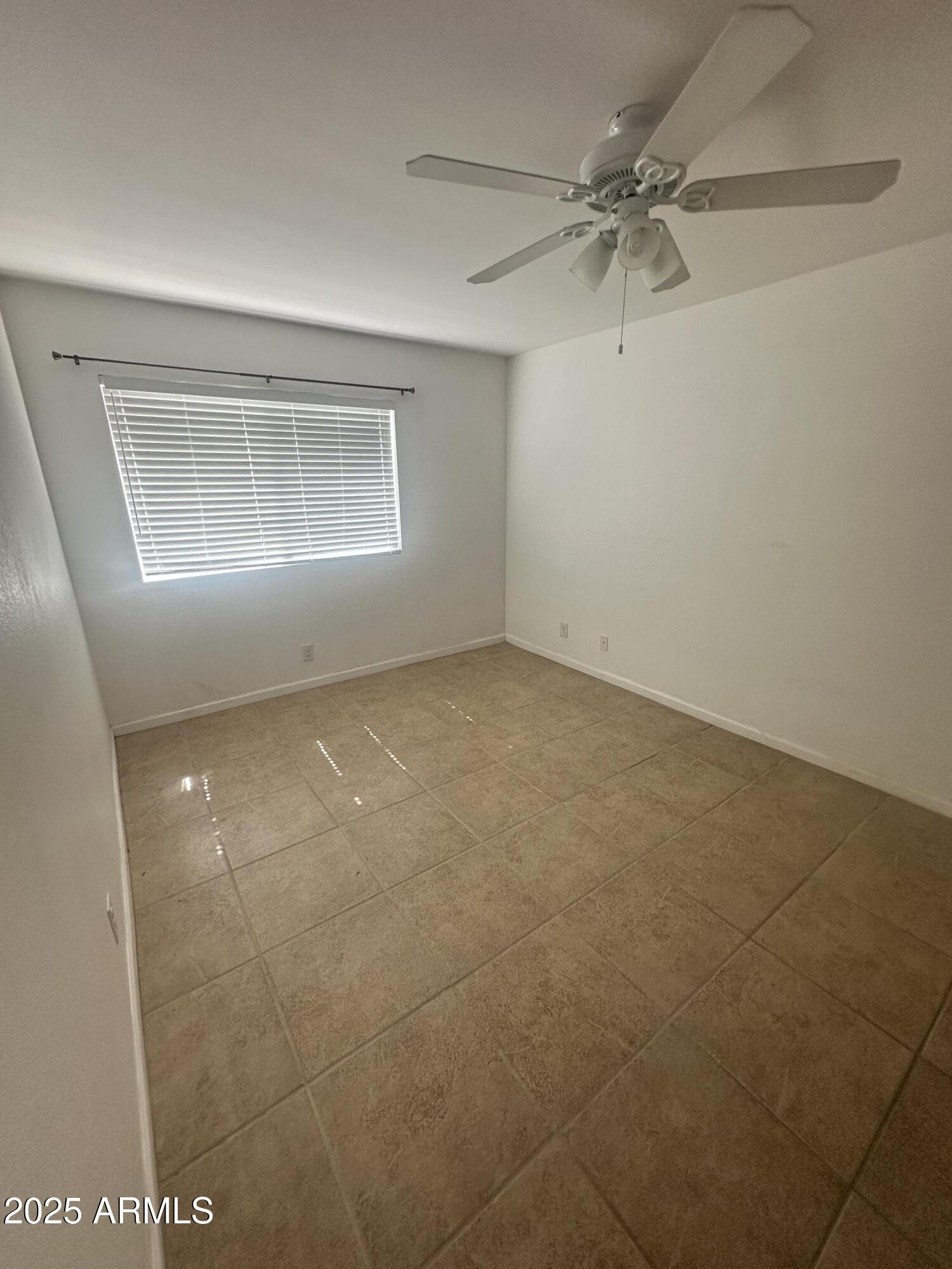 424 West Brown Road, Unit 122 Mesa, AZ 85201 - Photo 8 of 11 an empty room with a ceiling fan and a window