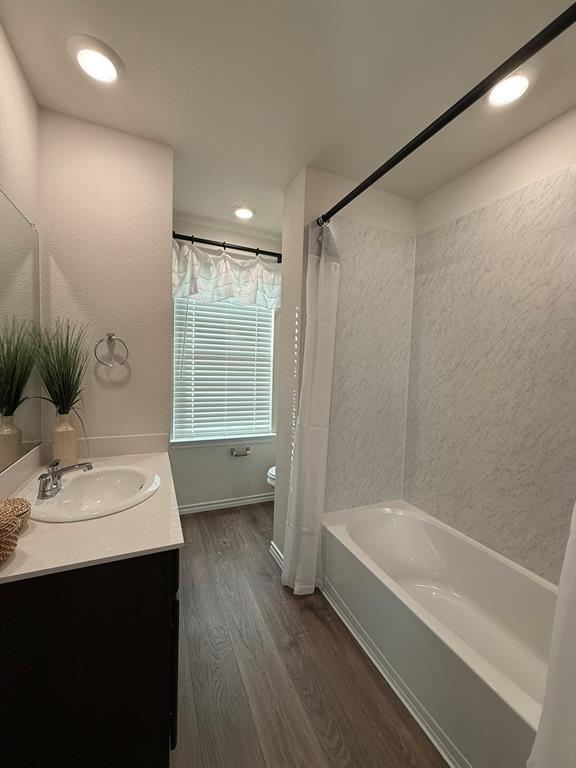317 Clematis Street Princeton, TX 75407 - Photo 31 of 38 Bathroom with dark wood-style floors, vanity, shower / bathtub combination with curtain, and recessed lighting