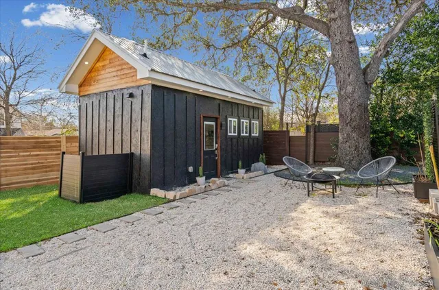 a backyard of a house with table and chairs
