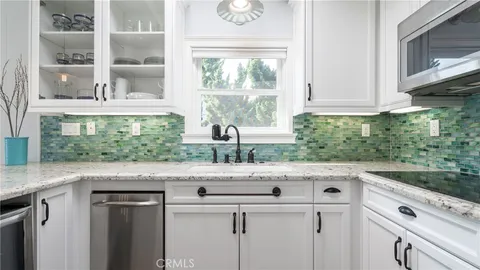 a kitchen with stainless steel appliances white cabinets and a window