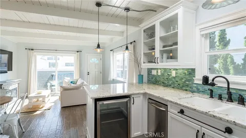 a kitchen with a sink stove and wooden floor