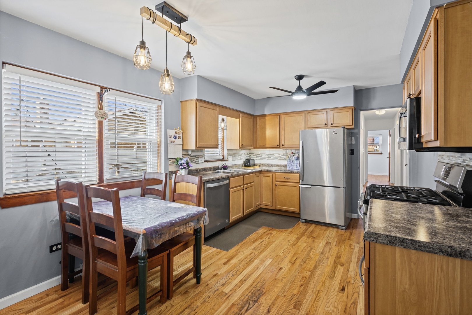 5901 108th Place Chicago Ridge, IL 60415 - Photo 4 of 15 a kitchen with a refrigerator a stove a sink dishwasher with a dining table and chairs with wooden floor