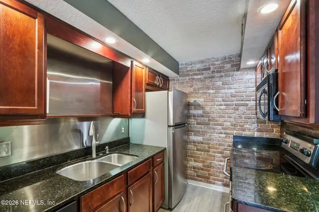 a kitchen that has a sink a stove and a microwave oven