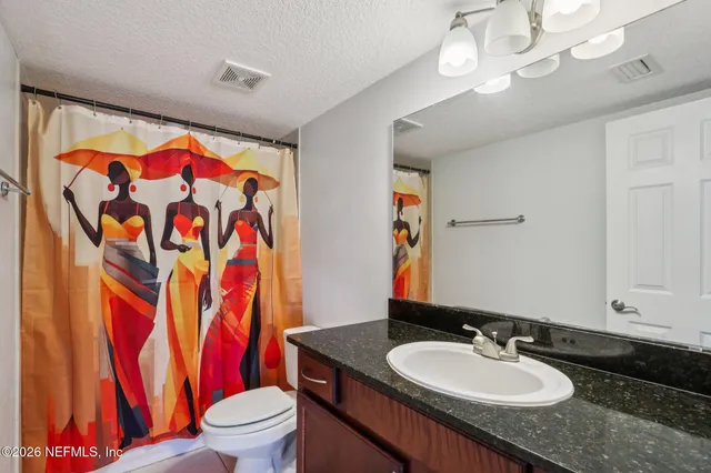 a living room with furniture and a painting on the wall