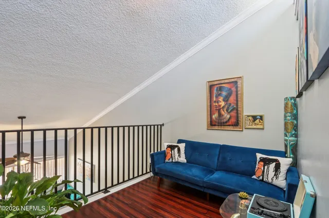 a blue couch sitting on a rug and a painting on the wall