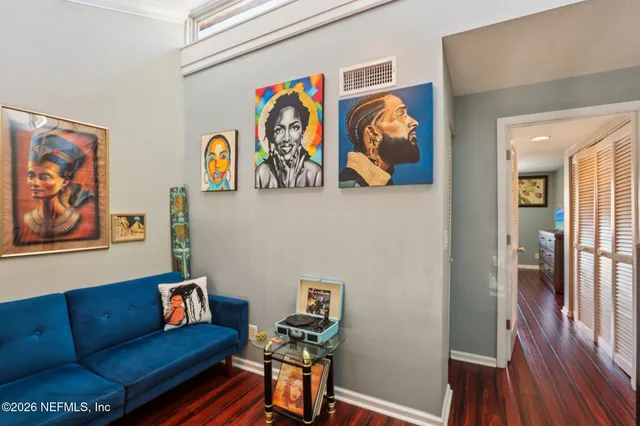 a view of a hallway with wooden floor and shoes