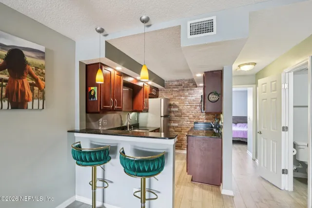 a kitchen with stainless steel appliances granite countertop a sink a stove and a wooden floors