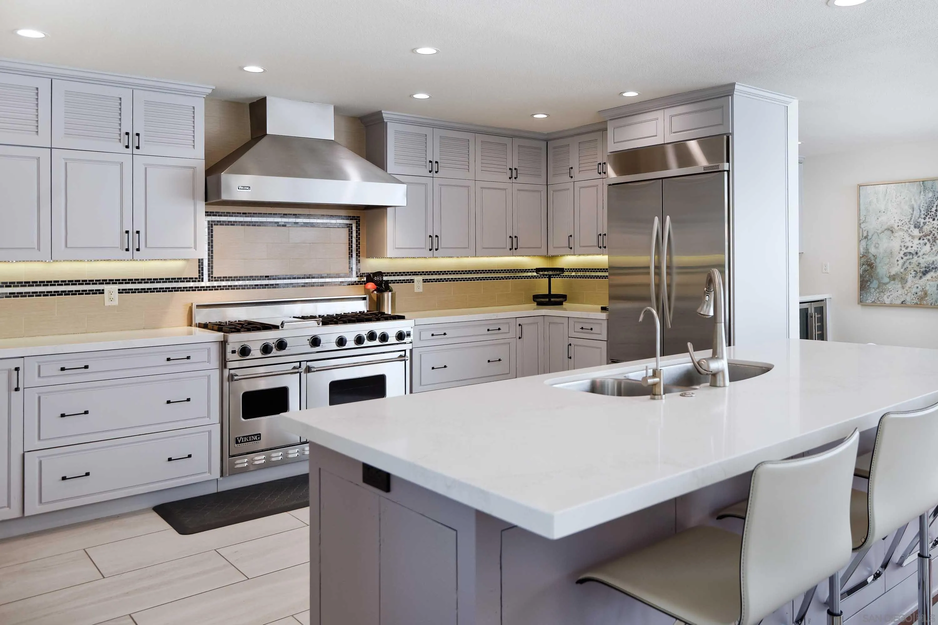 5459 Moonlight Lane La Jolla, CA 92037 - Photo 8 of 32 a kitchen with a sink a stove a refrigerator and white cabinets