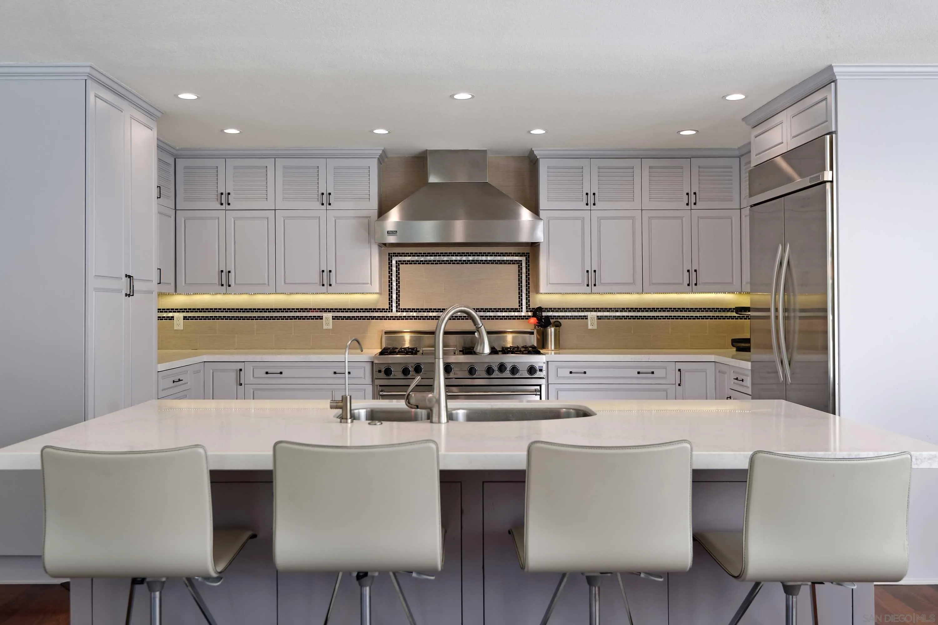 5459 Moonlight Lane La Jolla, CA 92037 - Photo 9 of 32 a kitchen with stainless steel appliances kitchen island granite countertop a sink and cabinets
