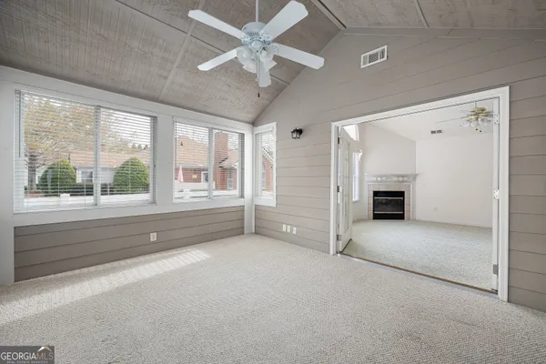 a kitchen with granite countertop a refrigerator a sink and white cabinets