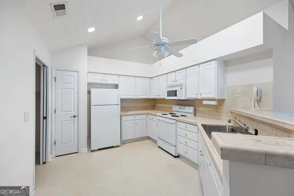a kitchen with white cabinets stainless steel appliances and sink