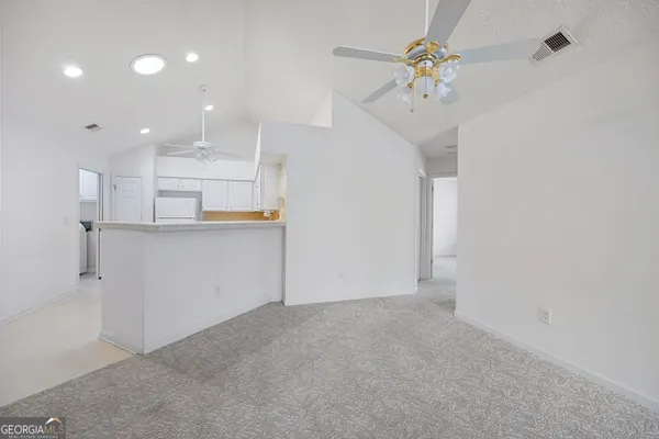 an empty room with windows and fan