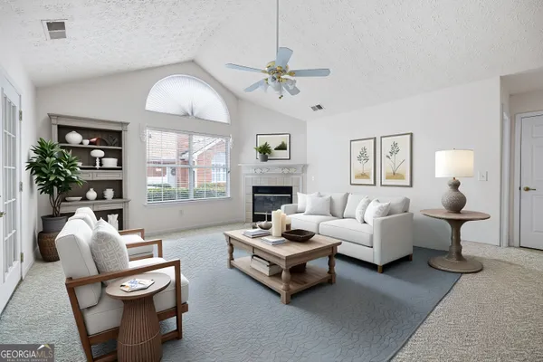 a living room with furniture fireplace and a large window