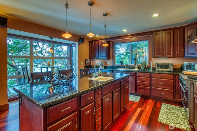 a kitchen with stainless steel appliances granite countertop sink stove and refrigerator