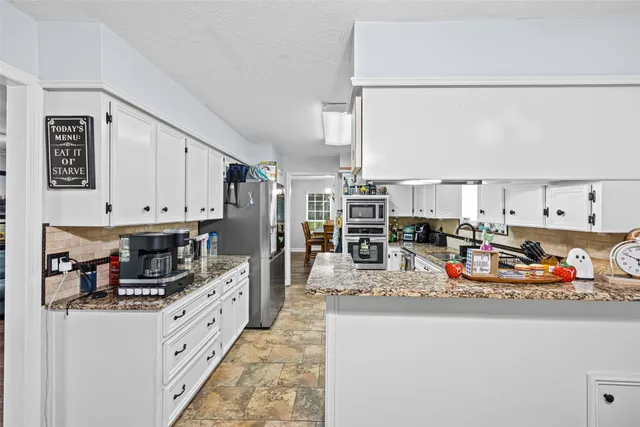 a kitchen with stainless steel appliances granite countertop a refrigerator and a stove