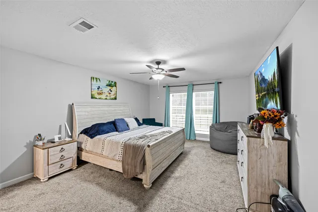 a bedroom with a bed furniture and a flat screen tv