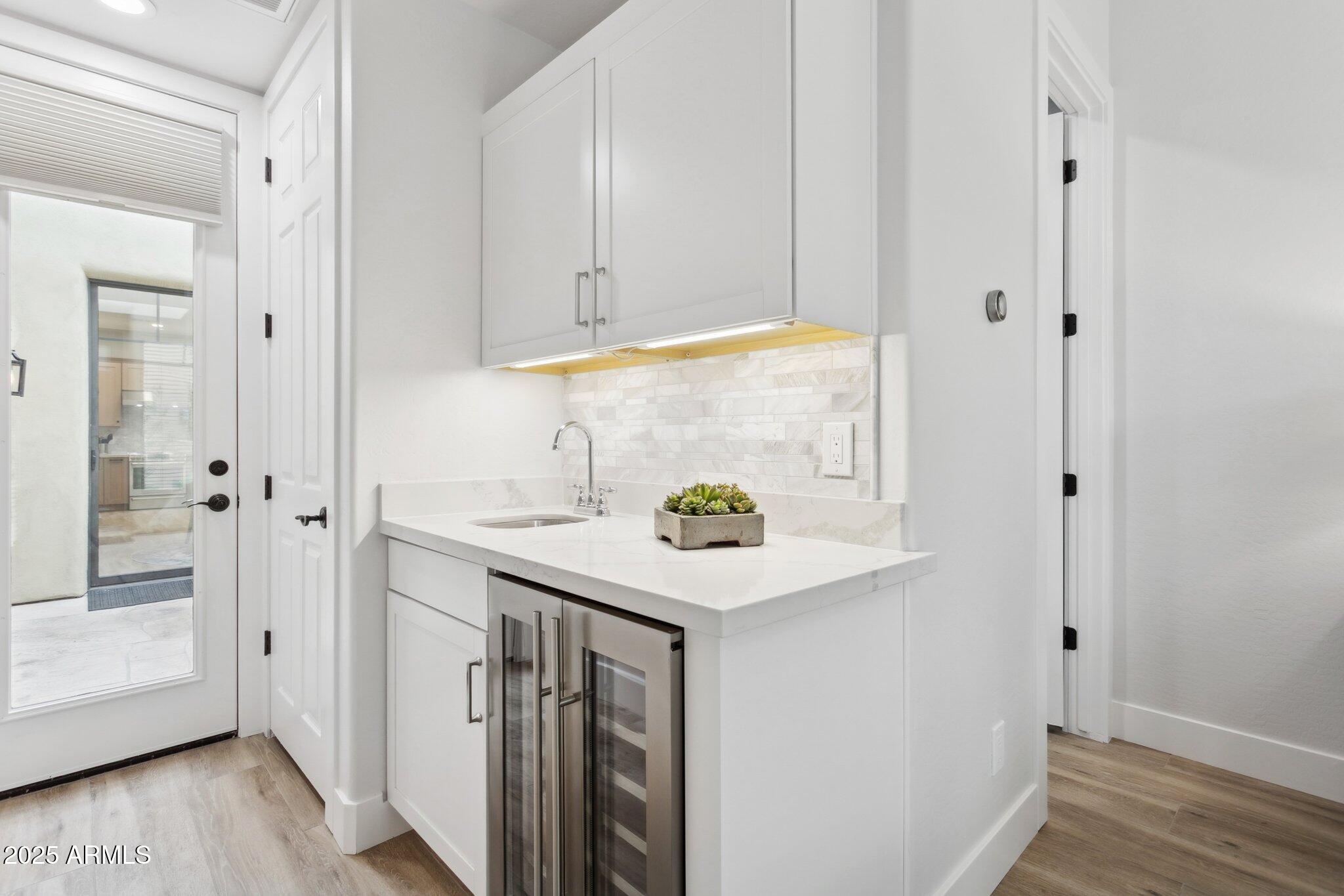 9270 East Thompson Peak Parkway, Unit 364 Scottsdale, AZ 85255 - Photo 25 of 45 a kitchen with stainless steel appliances a white cabinets and wooden floor