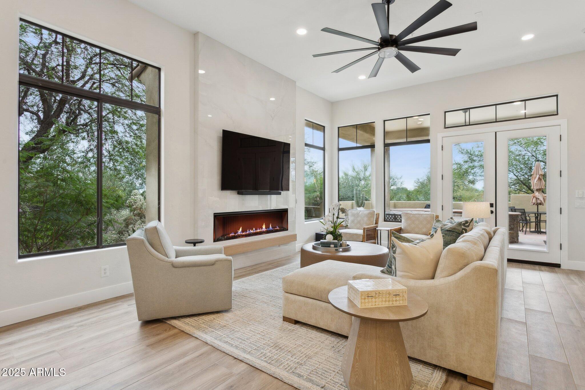 9270 East Thompson Peak Parkway, Unit 364 Scottsdale, AZ 85255 - Photo 7 of 45 a living room with furniture large windows and a fireplace