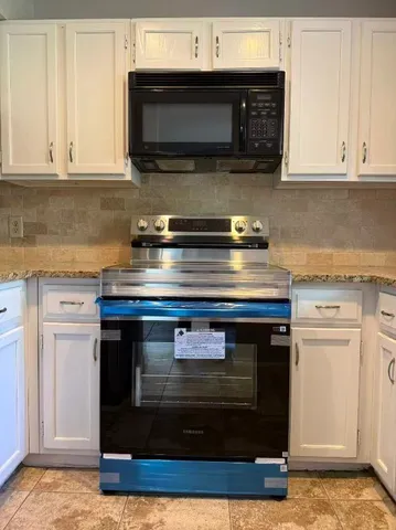 a stove top oven sitting inside of a kitchen