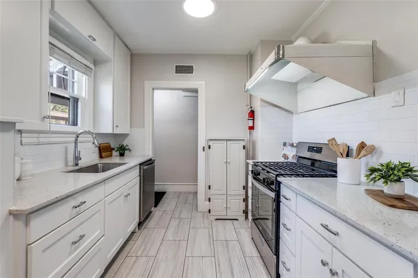 a kitchen with stainless steel appliances granite countertop a sink stove and refrigerator