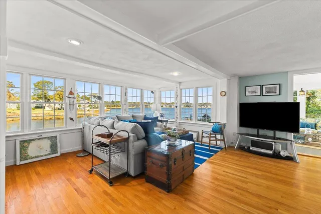 a view of a livingroom with wooden floor and a fireplace