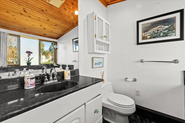 a kitchen with a stove a sink a microwave a refrigerator and white cabinets