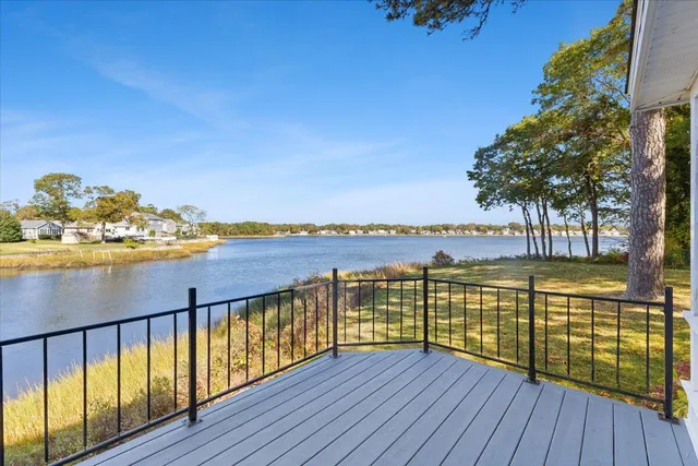a view of a white house with a big yard and large trees