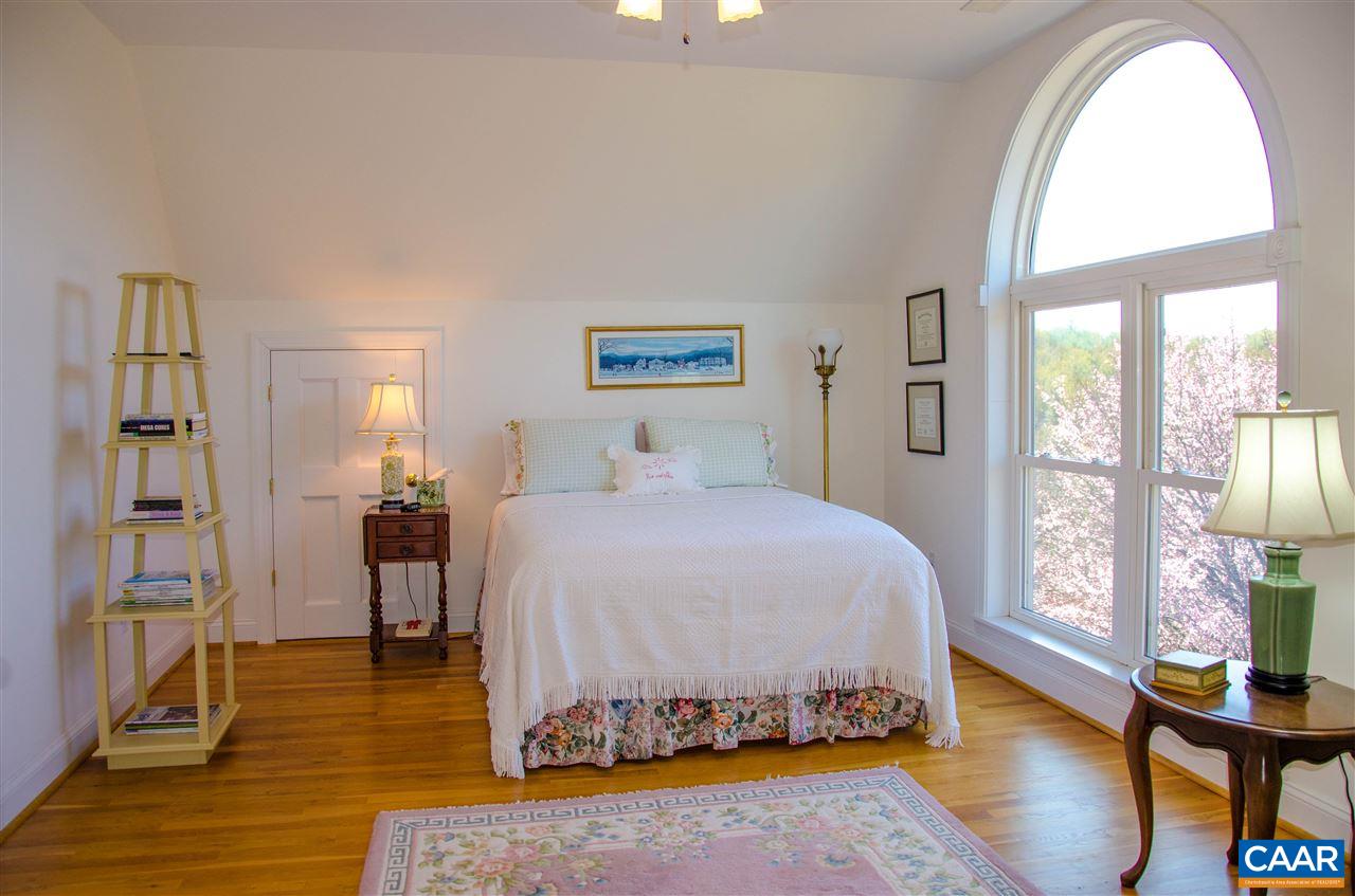 136 Fishpond Road Howardsville, VA 24562 - Photo 17 of 49 a spacious bedroom with a bed and wooden floor