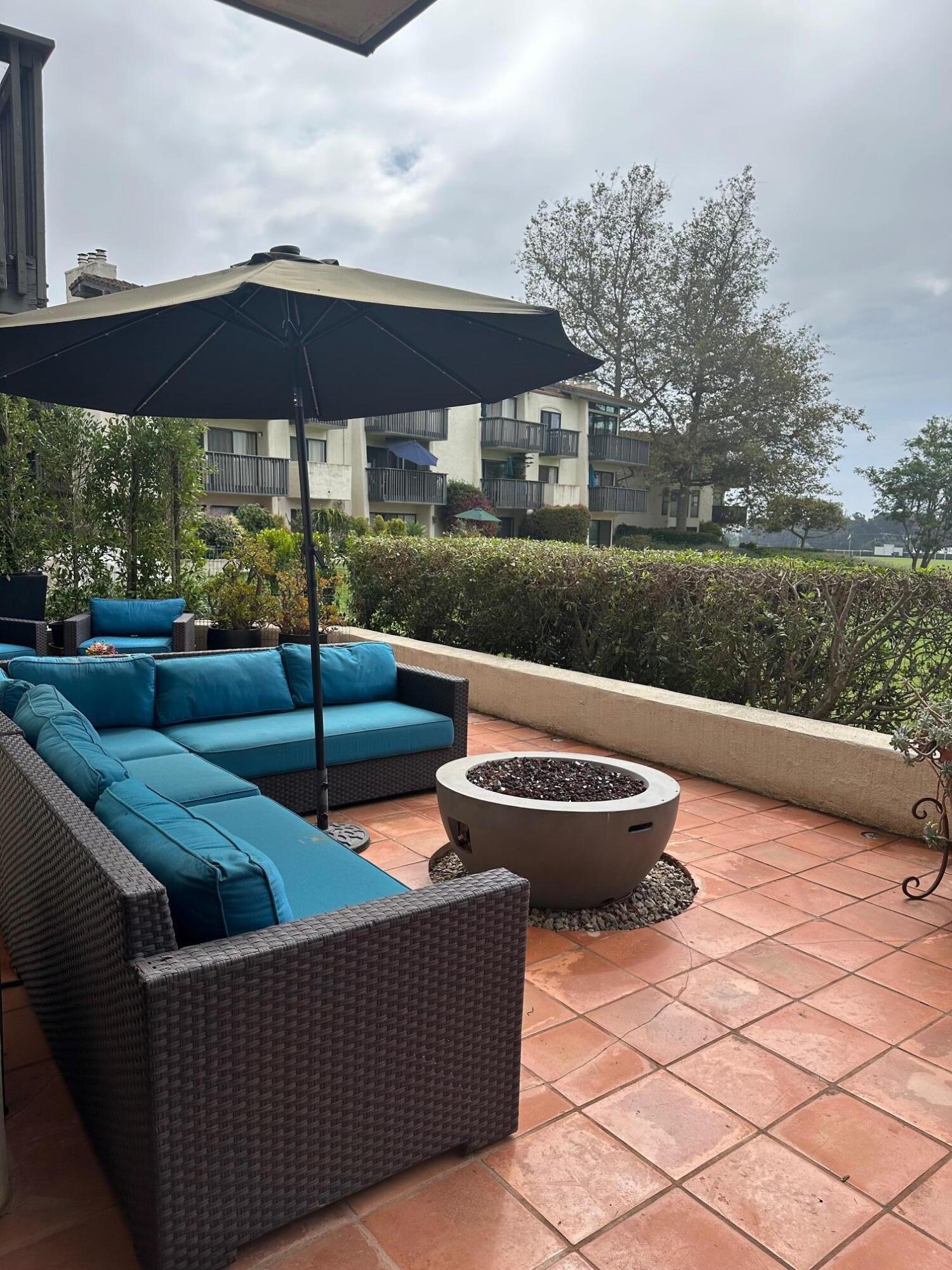 3375 Foothill Road, Unit 1114 Carpinteria, CA 93013 - Photo 16 of 17 a view of a patio with couches under an umbrella