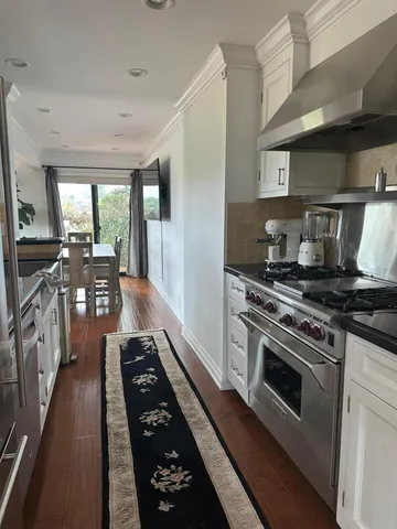 a kitchen with stainless steel appliances granite countertop a stove a sink dishwasher and a refrigerator