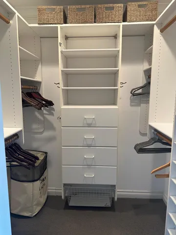 a view of walk in closet with clothes and shoes
