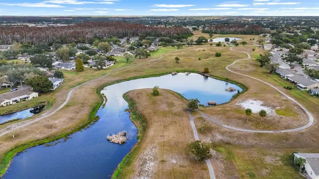 an aerial view of ocean and residential houses with outdoor space
